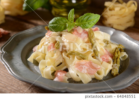 Tagiatelle pasta with asparagus and prosciutto ham Tagiatelle pasta with asparagus and prosciutto ham 64848551