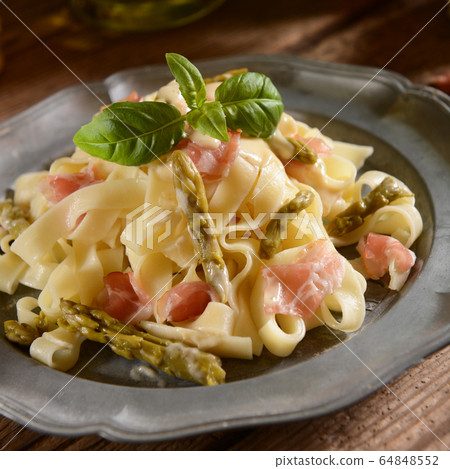 Tagiatelle pasta with asparagus and prosciutto ham Tagiatelle pasta with asparagus and prosciutto ham 64848552