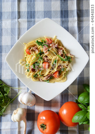 Spaghetti pasta with rucola, cherry tomatoes and 64848833