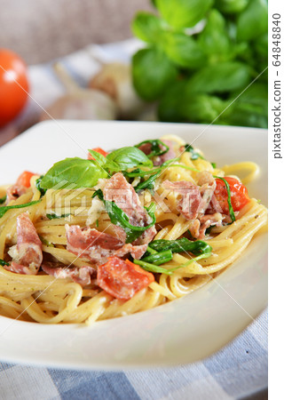 Spaghetti pasta with rucola, cherry tomatoes and 64848840