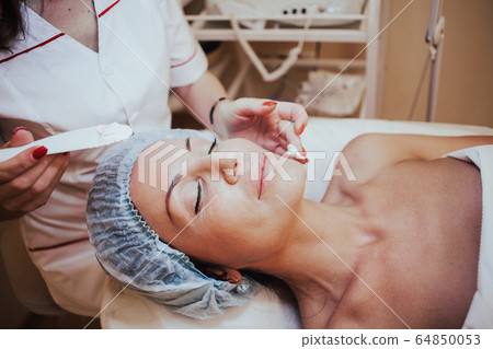 Cosmetology doctor makes woman treatments facial massage Cosmetology doctor makes woman treatments facial massage 64850053