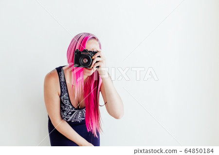 photographer girl with pink hair on a photo shoot with a camera 64850184