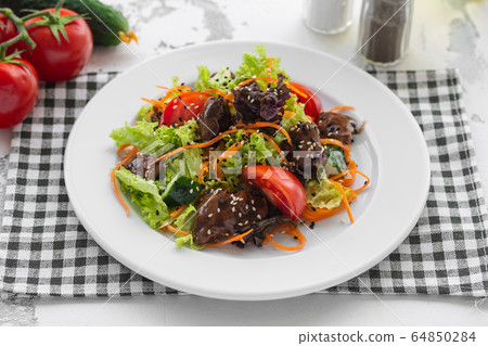 Salad of fresh vegetables, chicken liver and Korean carrots. 64850284