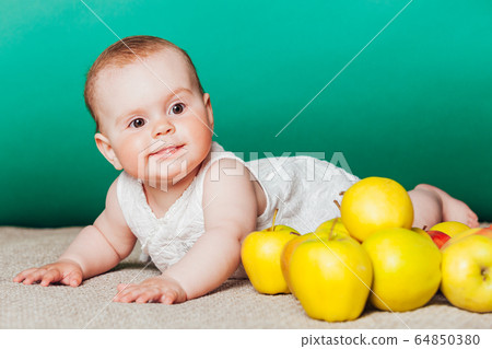 baby girl in a dress with Green apples 64850380