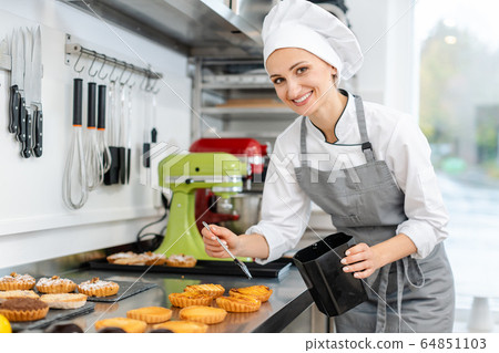 Pastry chef glazing little cakes Pastry chef glazing little cakes 64851103