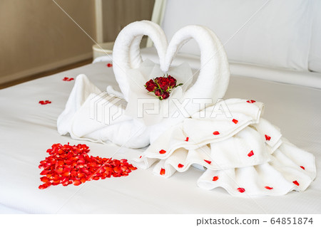 Swan towel on bed with red rose flower decoration interior 64851874