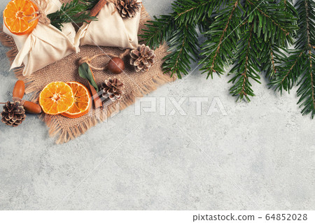Zero waste christmas concept. Packed in natural fabric gifts and decorations from natural materials on gray table, top view, copy space Zero waste christmas concept. Packed in natural fabric gifts and decorations from natural materials on gray table, top view, copy space 64852028