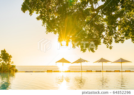 Beautiful tropical outdoor beach sea ocean with umbrella and chiar around outdoor swimming pool at sunset or sunrise time Beautiful tropical outdoor beach sea ocean with umbrella and chiar around outdoor swimming pool at sunset or sunrise time 64852296