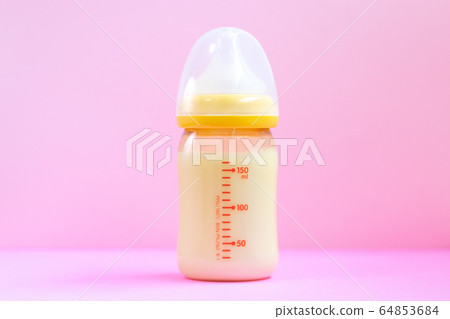 嬰兒奶瓶和玩具在粉紅色的背景上 64853684