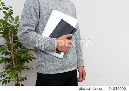 A man holding a PC and a notebook 64854090