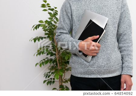 A man holding a PC and a notebook 64854092
