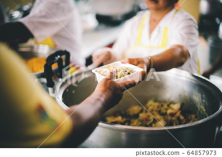 People holding a plate receiving a donation from a People holding a plate receiving a donation from a 64857973