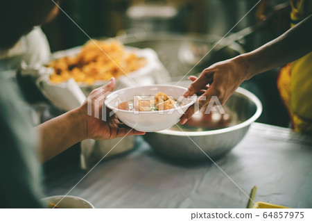 People holding a plate receiving a donation from a People holding a plate receiving a donation from a 64857975