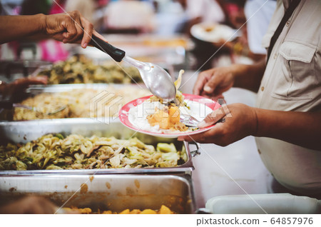 People holding a plate receiving a donation from a People holding a plate receiving a donation from a 64857976