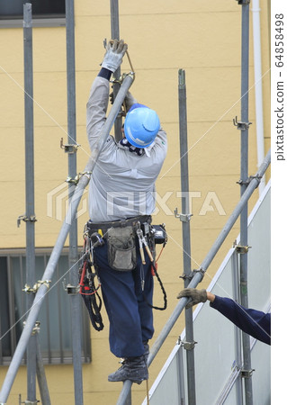 Workers removing the protective fence at the building demolition site 64858498