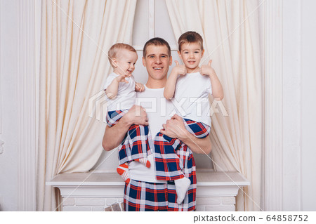 Warming and relaxing by the fireplace. parents with their son's child hug. The concept of family, motherhood, interior, home, childhood, mother's Day, the day of protection of children 64858752