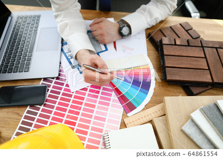 Male designer hand hold silver pen against color palette trend 64861554