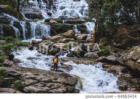Travel relax to visit the waterfalls of woman asian. at the waterfall mae ya chiangmai, summer Travel relax to visit the waterfalls of woman asian. at the waterfall mae ya chiangmai, summer 64863434