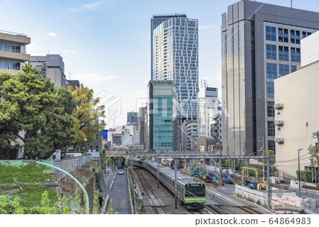 Urban scenery Shibuya redeveloped skyscrapers facing the railway image of a railway line in a large city 64864983