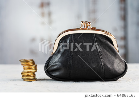 Wallet with gold coins on a gray background. Wallet with gold coins on a gray background. 64865163