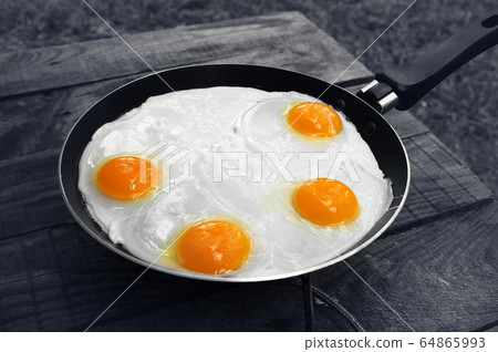 Old wooden table and frying pan with fried eggs on Old wooden table and frying pan with fried eggs on 64865993