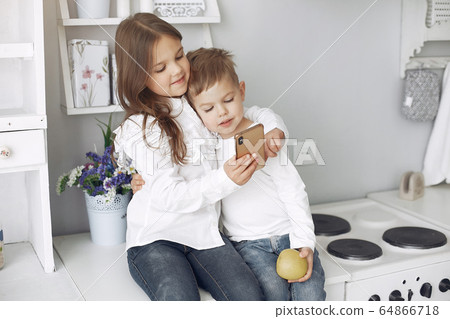 Children sitting in a kitchen at home Children sitting in a kitchen at home 64866718