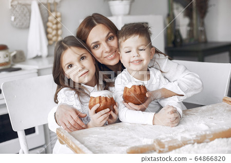 Family sitting in a kitchen and cook the dough for cake 64866820