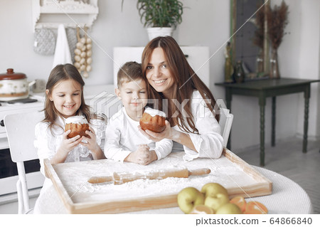 Family sitting in a kitchen and cook the dough for cake 64866840