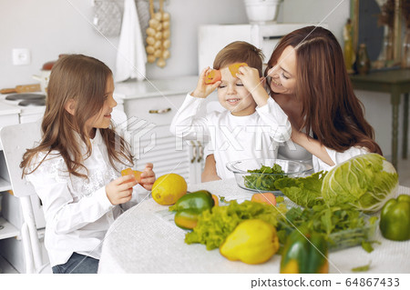 Family prepare the salad in a kitchen 64867433