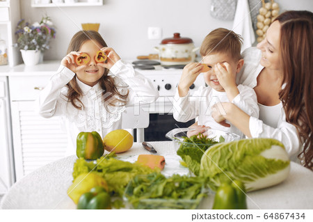 Family prepare the salad in a kitchen 64867434