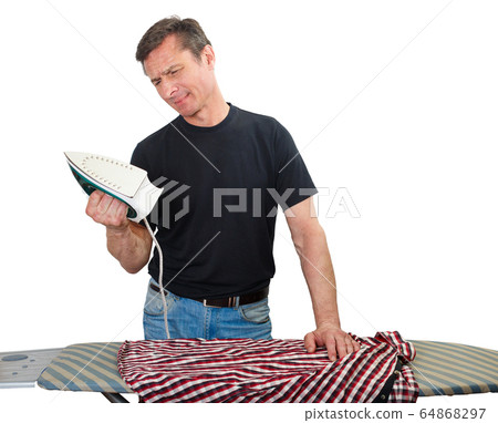 Adult man irons his shirt Adult man irons his shirt 64868297