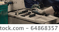 Industrial worker in gloves operating machine on 64868357