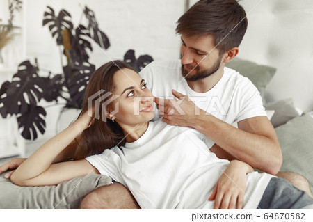 Couple sitting on a bed in a room 64870582