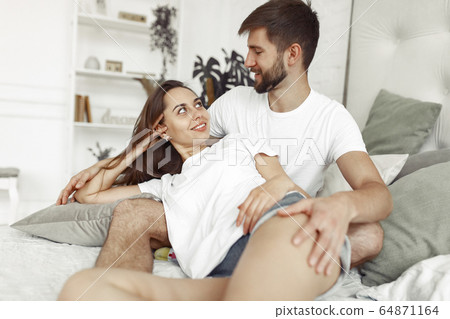Couple sitting on a bed in a room 64871164