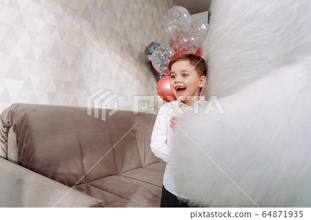 a boy hugs a big bear at hone on party 64871935