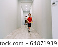 the boy runs down the hall of the house 64871939