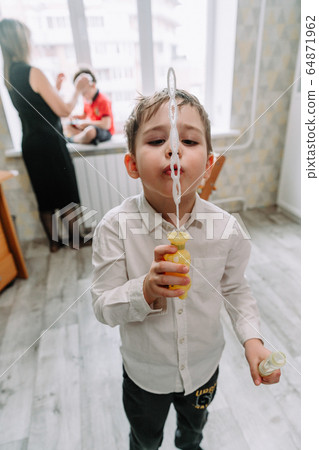 Child playing with soap bubbles in the home 64871962