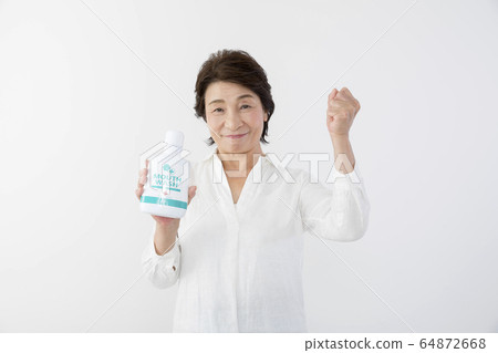 Senior woman with mouthwash 8020 exercise 64872668