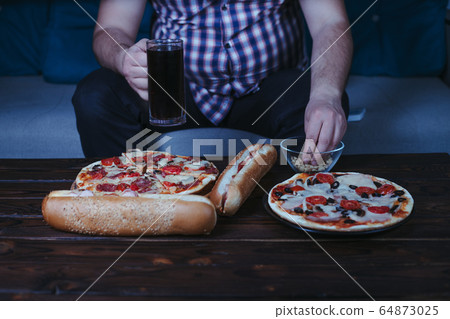 Overweight man with big amount of junk food 64873025