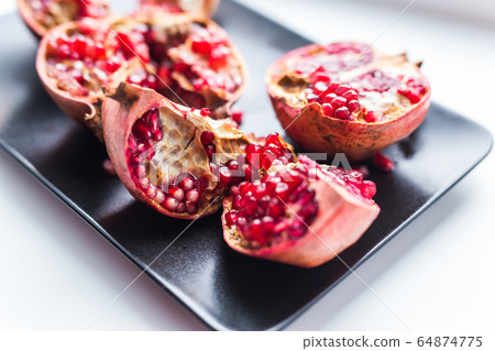 Big ripe red garnet. Fruits of red ripe pomegranate on the windows sill. Vegetarian, Organic vitamins, detox, diet concept. Organic and benefit garnet fruit. Big ripe red garnet. Fruits of red ripe pomegranate on the windows sill. Vegetarian, Organic vitamins, detox, diet concept. Organic and benefit garnet fruit. 64874775
