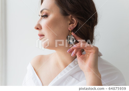 Elegant woman with earrings, close up portrait. Accessories, jewelry and bijouterie concept. 64875939