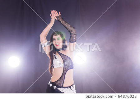 Young woman dancing in Tr Copy space.ibal Fusion style. Belly dance on the stage. 64876028