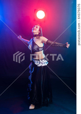 Spirituality dance. Beautiful sexy woman with luxury glossy eastern make-up dancing tribal fusion. Belly dance. 64876076