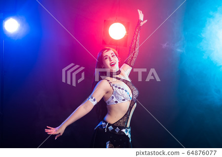 Young woman dancing in Tribal Fusion style. Belly dance on the stage. 64876077
