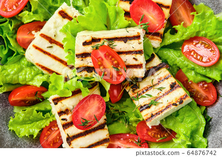 Macro photo of salad with grilled halloumi cheese, tomato and wine sauce 64876742