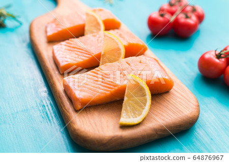 Fresh raw salmon on wooden cutting board. Fresh raw salmon on wooden cutting board. 64876967