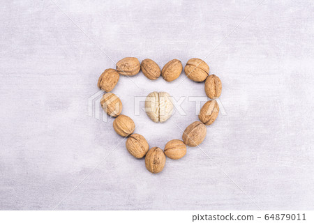 Walnuts love healthy brain foods. The shape of the human brain is surrounded by walnut kernels in the shape of a heart Walnuts love healthy brain foods. The shape of the human brain is surrounded by walnut kernels in the shape of a heart 64879011