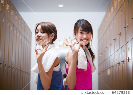 Young woman doing ok sign at gym gym locker 64879218
