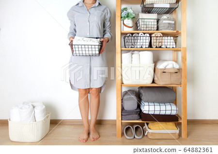 Bed sheets, duvet covers and towels are folded vertically. Metal and fabric black baskets. The concept of housework and storage. Bed sheets, duvet covers and towels are folded vertically. Metal and fabric black baskets. The concept of housework and storage. 64882361