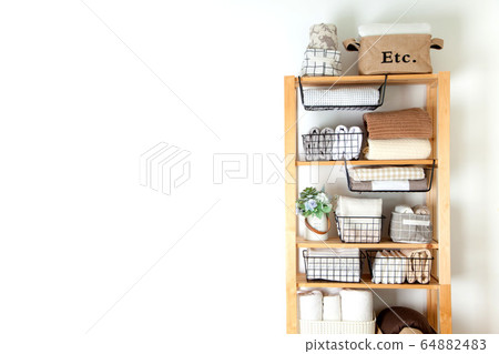 Bed sheets, duvet covers and towels are folded vertically. Metal and fabric black baskets. The concept of housework and storage. 64882483